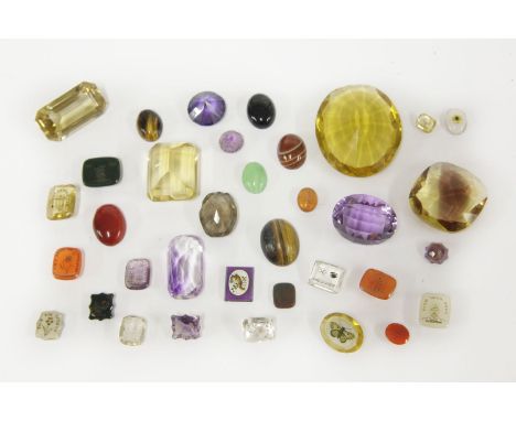 A collection of gemstones and paste stones to include two mixed cut citrines, two amethysts, a smokey quartz, tiger's eye cab