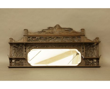 A Japanese hardwood overmantel mirror, the shaped bevelled plate with shelf above, surmounted by a pierced and carved crestin