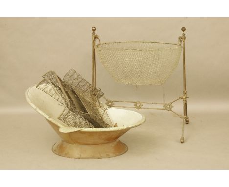 A French cast iron and brass baby's crib, 92cm long, together with a part fireguard and an enamelled hip bath on circular fee