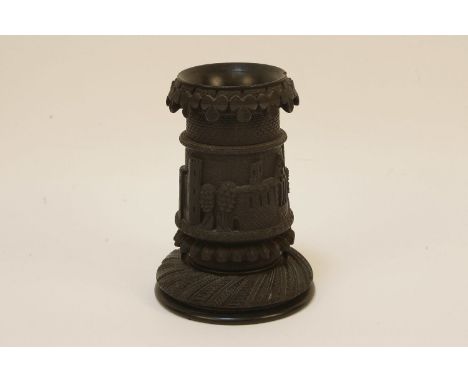 A small turned and carved Irish bog oak spill and vase, decorated with wolf hound, harp and shamrock designs, 15.5cm tall