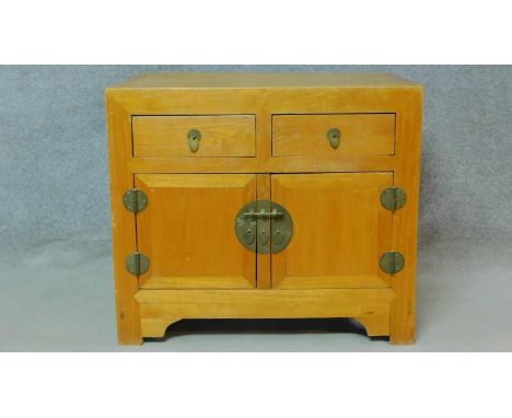 A Chinese side cabinet with two frieze drawers above panel doors on bracket feet. H.81 W.93 D.63cm 