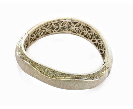 A Diamond Bangle, the textured white bangle with eight-cut diamond detailing, in pavé settings, inner measurements 5.5cm by 4