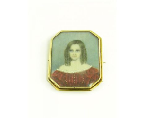 AN OCTAGONAL PORTRAIT MINIATURE WEARING HER HAIR IN RINGLETS, IVORY, MOUNTED IN A GOLD BROOCH WITH GLAZED BACK