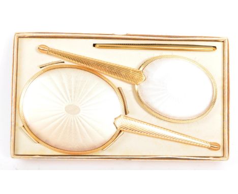 An Art Deco 1940s three piece vanity set. Comprising of clothes brush, comb and hand mirror.&nbsp; Of oval form with gilt fin