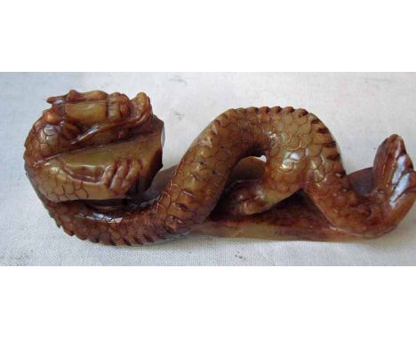 A large Chinese carved jade/hardstone paperweight as a resting dragon, 25cm long 