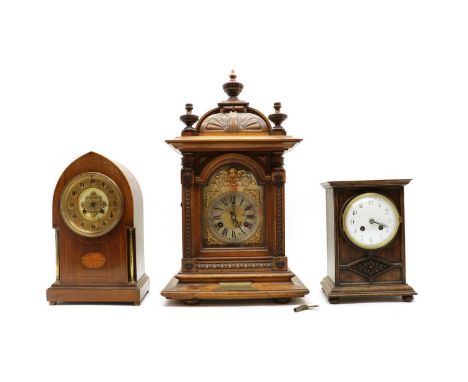 An Edwardian inlaid mahogany lancet top mantel clock,the 5inch gilt dial within a boxwood strung case centred by a hardwood a