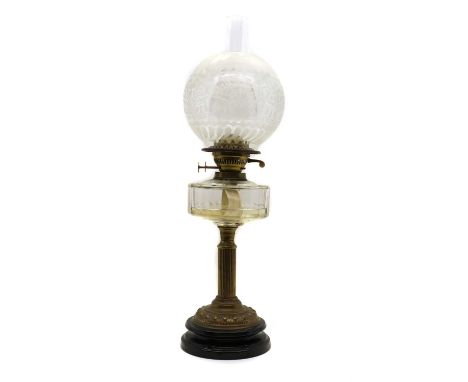 A Edwardian brass column oil lamp,the glass reservoir with etched shade and clear chimney over a fluted column raised on squa
