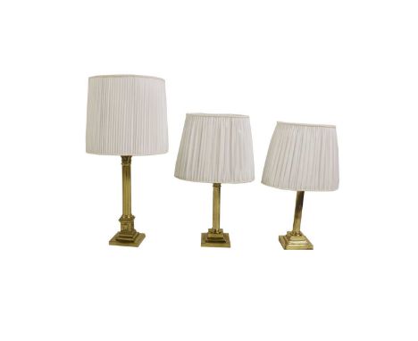 A pair of Victorian brass column lamps,the fitting leading to Composite columns on stepped square bases, with oval shades, 43
