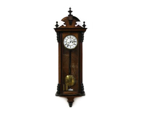 A Victorian walnut Vienna Regulator wall clock,with a white enamel dial and two train movement, the case with turned finials,