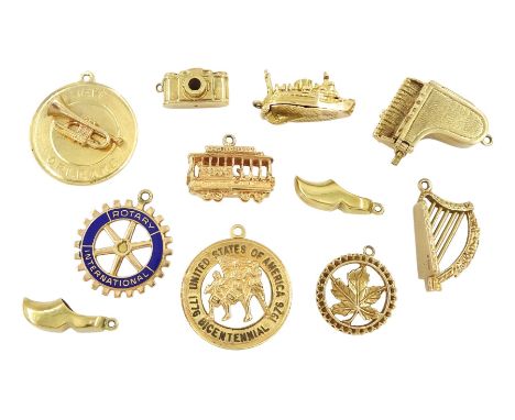 Gold pendant / charms including 9ct gold piano, harp, camera, Canada and ship, 10ct gold Rotary International and 14ct gold c