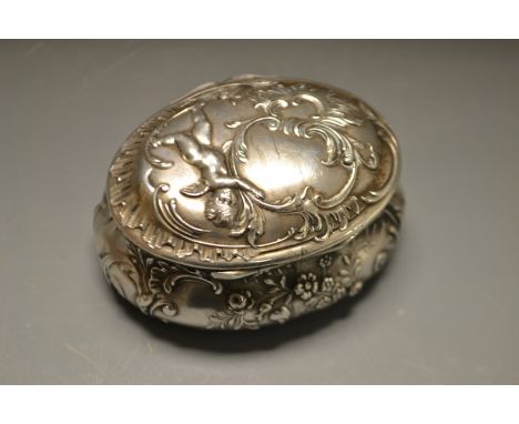A 19th century oval silver cherub snuff box, gilt interior