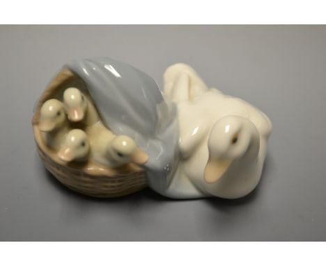 A Lladro model of a  duck with a basket of ducklings