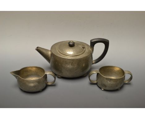 A Trudric pewter three piece tea service, for Liberty's, planished ground, serial number 01536, stamped, ninetieth century. 