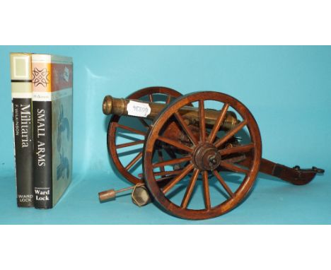 A Bassett Lowke style bronze canon, on a carriage, 15.5 cm high, and two militaria related books (3)