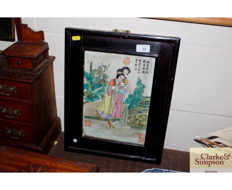 A Chinese porcelain famille rose decorated panel depicting figures with various character and red seal marks in a frame 