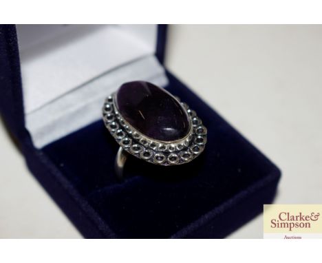 An amethyst coloured and white metal dress ring 