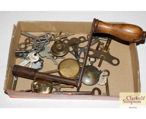 A collection of various clock keys, pendulums and a table winder