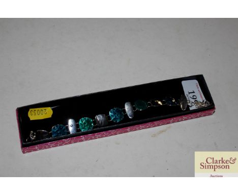 A white metal and green enamel bracelet 