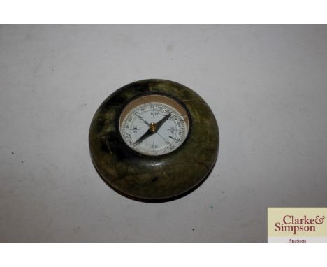 A green stone paperweight inset with a compass