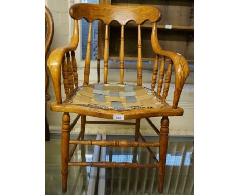 An early 20th Century light oak spindle back captains armchair. 