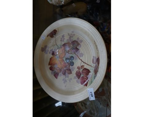 A Clarice Cliff charger with hand painted decoration of autumn leaves and berries signed F. Ridgway.
