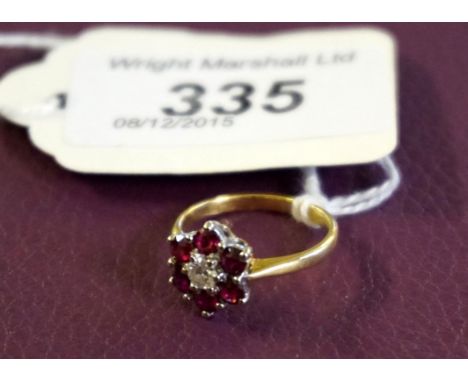 A ruby and diamond set cluster ring, the central round brilliant cut diamond claw set to a border of six round cut rubies, th