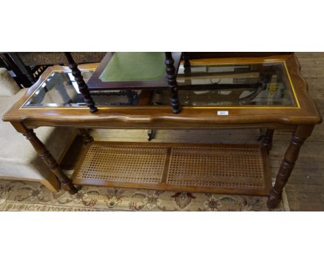 A reproduction mahogany side table having two glass panel tops, raised on column supports.