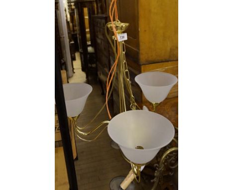 A gilt metal glass effect ceiling lamp having three frosted glass shades. 