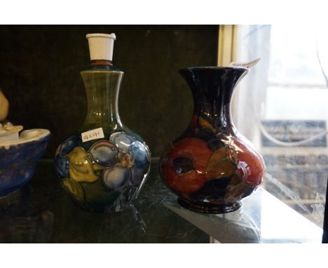 Two pieces of Walter Moorcroft to include a lamp decorated in the Clematis pattern and a baluster form vase in the Pomegranat