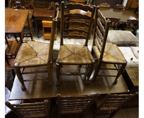 Six early 20th Century ladder back rush seated dining chairs, one carver. (5+1)