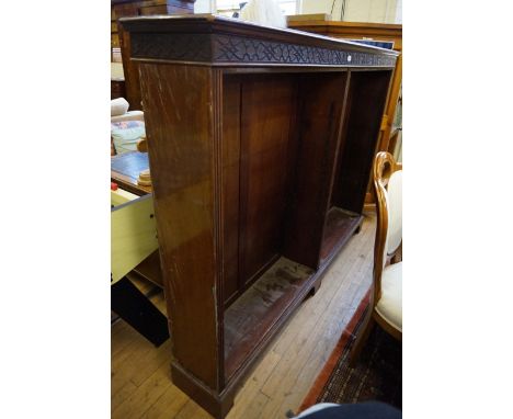 An Edwardian mahogany bookcase of large proportions, having blind fret decoration, raised on bracket supports, (lacking shelv