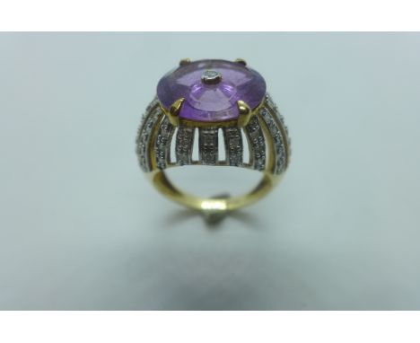 A 9ct gold amethyst and diamond ring, the large multi faceted amethyst centre drilled and set with a small round cut diamond,