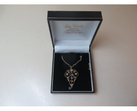 A 9ct gold amethyst and seed pearl Art Nouveau style pendant set with two round cut amethysts and twelve seed pearls in flora