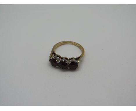 An 18ct gold garnet three stone ring, size J 1/2 - weight approx 4.3 grams, some rubbing to stones and surface marks consiste