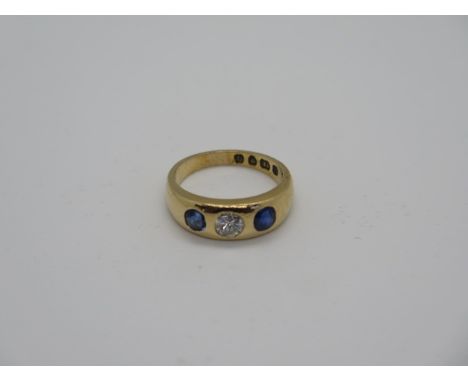 A hallmarked 18ct yellow gold diamond and sapphire three stone ring, size L/M, approx 6 grams, central diamond 0.33ct, dents 