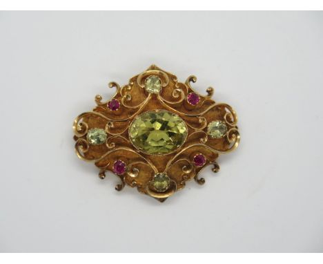A gold peridot and ruby brooch, 4x3.5cm, central stone approx 13x10x6mm, tests to approx 18ct, total weight 12.8 grams, gener