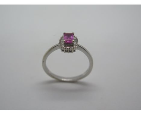 An 18ct gold, possibly pink sapphire and baguette cut diamond ring, the central emerald cut stone measures approx 6mm x 4mm -