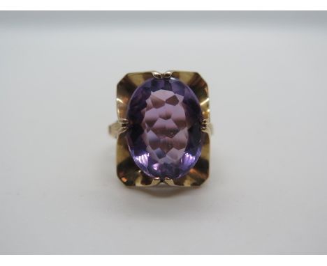 A 9ct gold and amethyst Art Nouveau style ring, set with a large oval amethyst measuring approx 15mm x 11mm - held in a ribbo