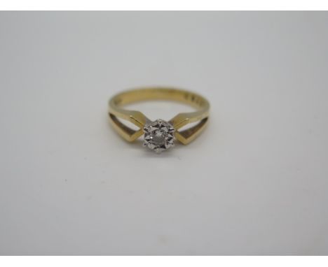 An 18ct gold diamond solitaire ring, the small brilliant cut stone set in a white illusion setting with yellow gold band, siz