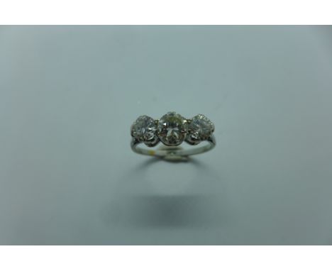 A three stone diamond and platinum ring, the central stone approx 0.60ct, flanked by two smaller diamonds each approx 0.30ct,