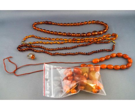 A selection of amber jewellery to include three strung necklaces, a partially strung necklace, a selection of bagged beads (l