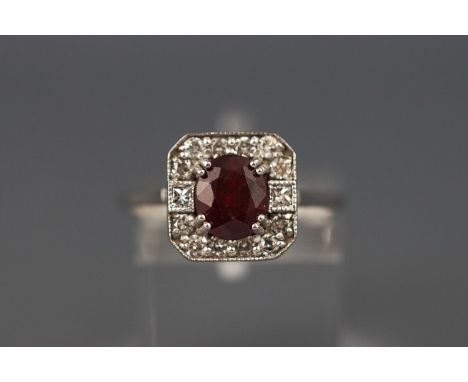 A white metal ruby and diamond cluster ring. Ruby approx 1.47ct. Diamond approx 0.30ct Hallmarked 18ct gold, Birmingham. Size