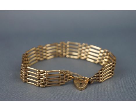 A yellow metal five bar and basket gate bracelet with padlock and safety chain. Hallmarked 9ct gold, London, 1989. 9.5 grams