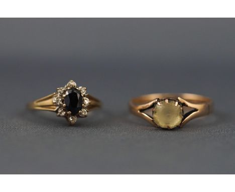 A selection of two hallmarked 9ct gold dress rings to include a sapphire and diamond cluster , size K, and a single stone yel