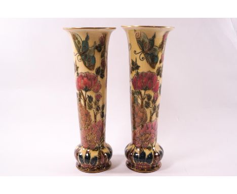 A pair of Zsolnay Pec earthenware vases of tapering cylindrical form, decorated with large flowering blooms and butterflies i