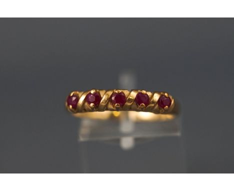 A yellow metal half hoop ruby ring. Hallmarked 9ct gold, Birmingham, 1995. Size: O 2.0 grams