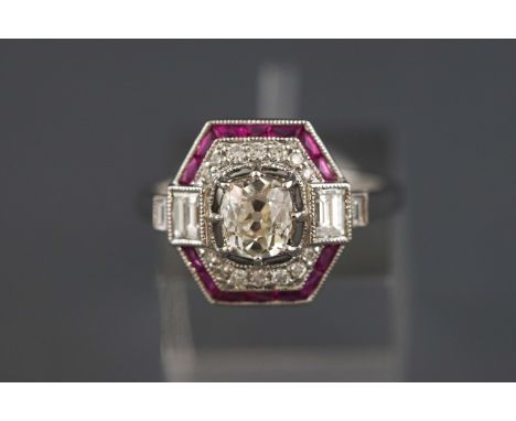 A white metal ruby and diamond dress ring. Centrally set with and old brilliant cut diamond estimated to weigh 0.64 carats. C