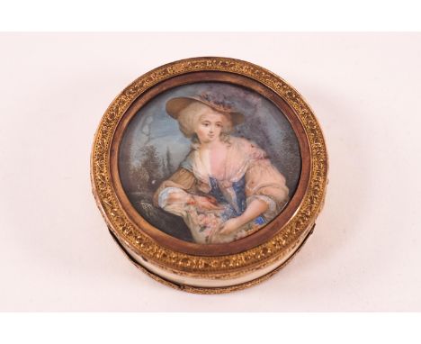 An 18th century circular ivory box, the cover inset with a painted portrait of a lady in a bonnet, decorative gilt metal rim 