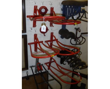 A set of four plastic coated wall-mounted saddle racks and two bridle racks, together with a pair of black leather riding boo