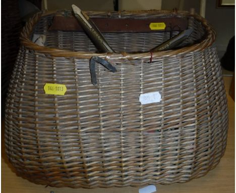 A fly fisherman's wicker creel with fish hole lid containing a quantity of fishing tackle to include an Arrow Cast fly line d